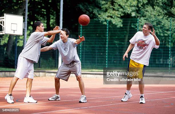 Germany: Free time.- Young persons playing basketball.