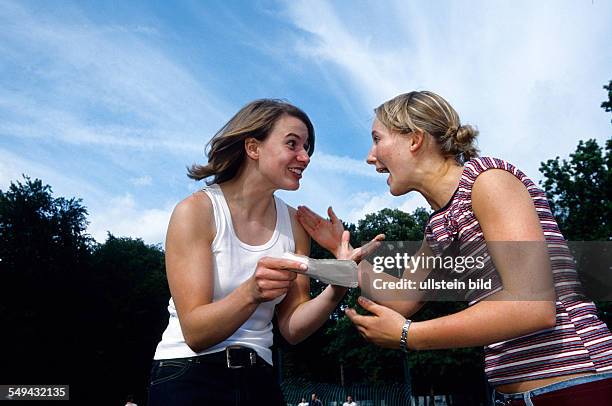 Germany: Free time.- Two women are happy, one of them has a piece of paper in her hand.