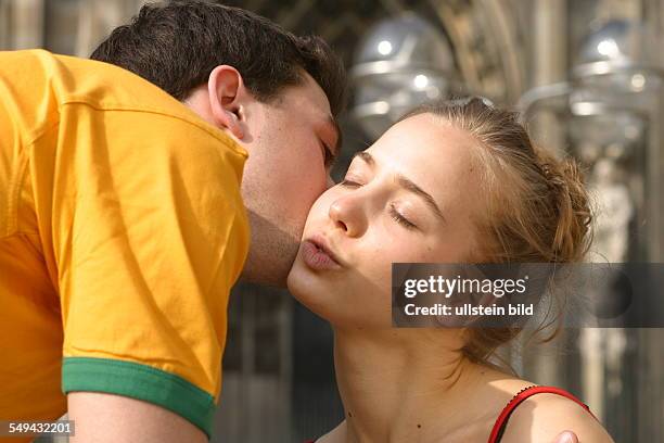 Germany, Cologne: Youth in their free time.- Friends kissing each others cheek.