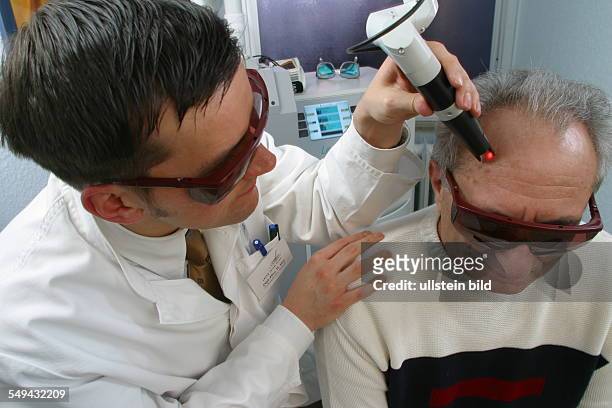 Germany, Essen, medicine physicist and non-medical practitioner Holger May, manager of the Laser Forum Essen. A patient during a laser treatment. Age...