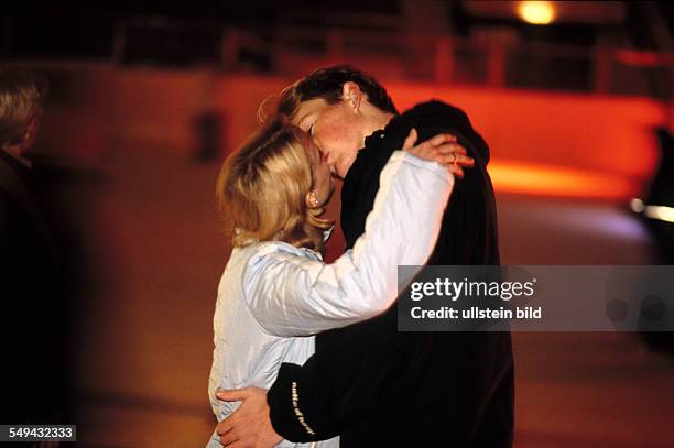 Germany: Free time.- A young couple skating in an ice-skating rink; they are kissing.