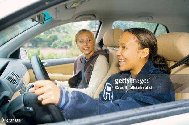 Germany: Free time.- Two young women in a car.