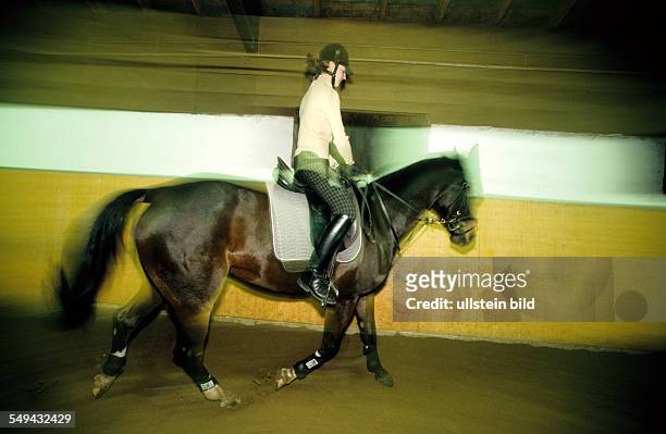 Deutschland: Freizeit.- Junge Frau beim Reiten einer Halle. L DEU, Germany: Free time.- Young woman riding in a hall.
