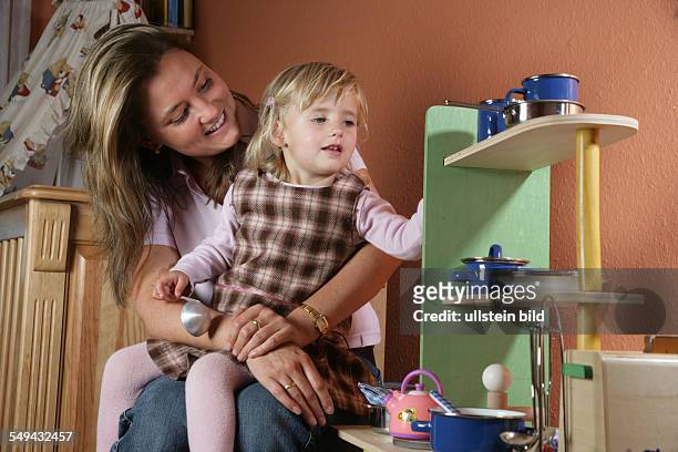 Germany, Essen: Portrait of a young mother playing with her little daughter.