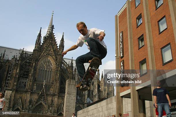 Germany, Cologne: Young persons in their free time.- Skateboarding; portrait of a young man. Young persons in their free time.- A young woman buying...