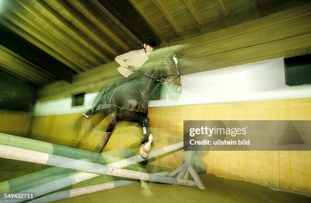 Deutschland: Freizeit.- Junge Frau beim Reiten einer Halle; Springreiten. L DEU, Germany: Free time.- Young woman riding in a hall.