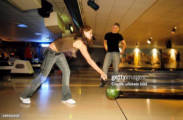Germany: Free time.- Young persons bowling; at the bowling alley.