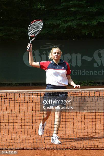 Germany, : A young woman on a tennis court.