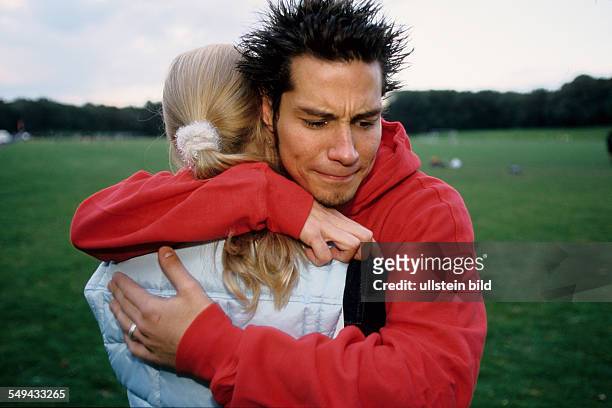 Germany: Free time.- Two youth on a meadow; they are embracing each other.