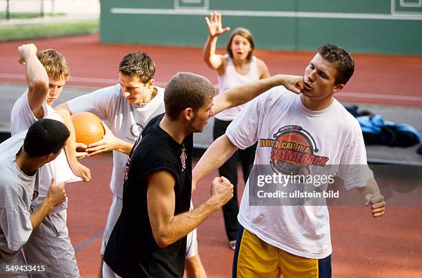 Germany: Free time.- Young men playing basketball; confrontation.