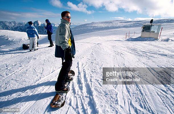 Germany: Free time.- Young persons skiing and snowboarding in the mountains.