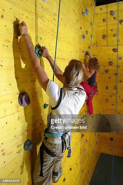 Germany, : Free time/sport.- Two young persons climbing up a climbing wall.