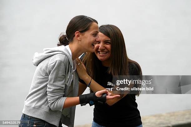 Germany, : Free time.- Two young women having fun while they are skating.