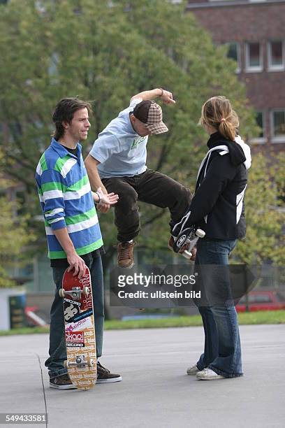 Germany: Young persons in their free time.- Friends skateboarding; discussion between a young couple.