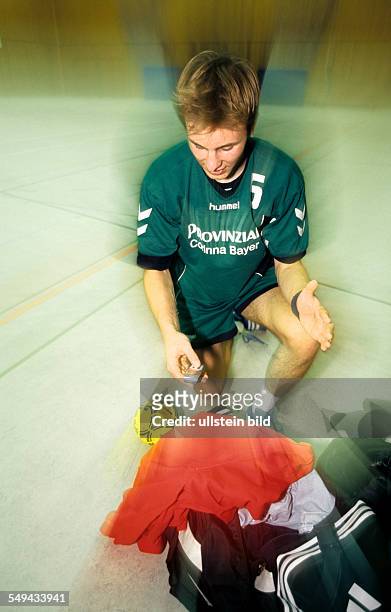 Germany: Free time.- Handball player; he is looking on his mobile phone.
