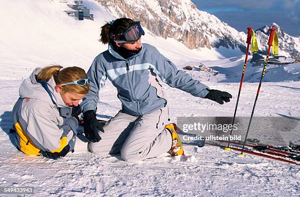 Germany: Free time.- Young persons skiing and snowboarding in the mountains; fall.