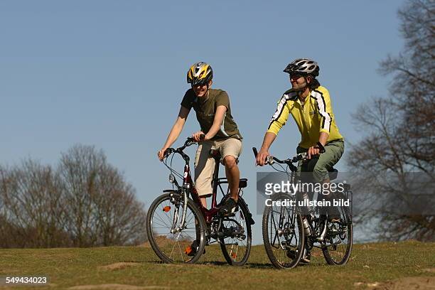Germany, Cologne: Free time.- Young couple on their mountainbike tour through the green.