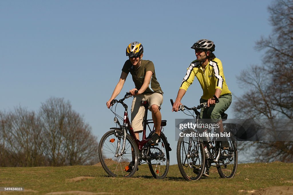 DEU, Germany, Cologne: Free time.- Young couple on their mountainbike tour through the green.