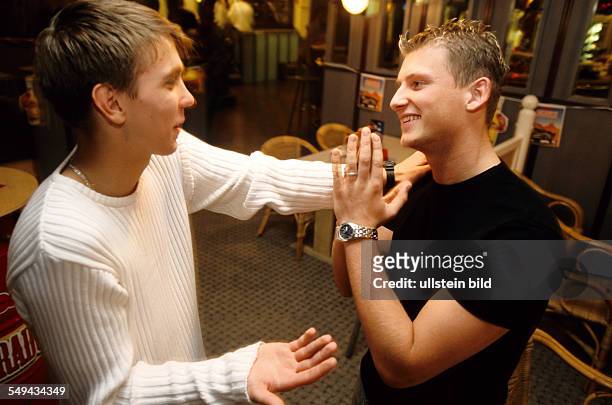 Germany: Free time.- Young persons bowling; two young men talking.