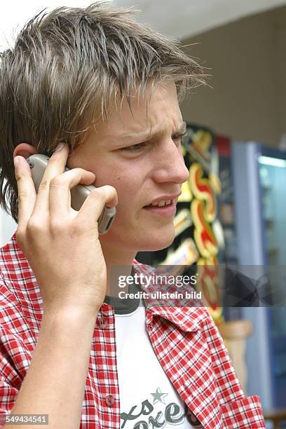 Germany, : Free time.- Portrait of a young man; he is phoning with his mobile phone.
