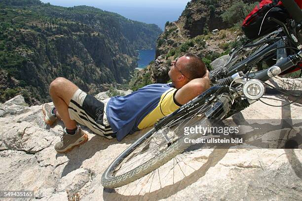 Turkey: A man is taking a break during his bicycle tour in the mountains.