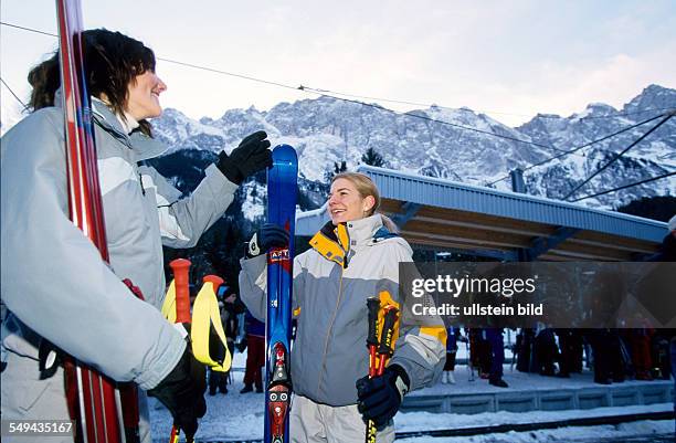 Germany: Free time.- Young persons going for skiing in the mountains.