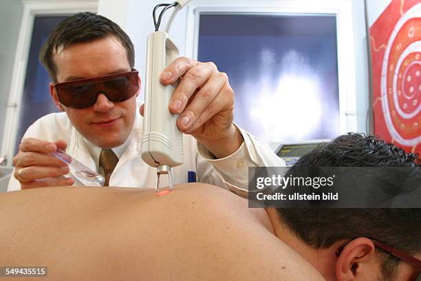 Germany, Essen, medicine physicist and non-medical practitioner Holger May, manager of the Laser Forum Essen. A patient during a laser treatment....