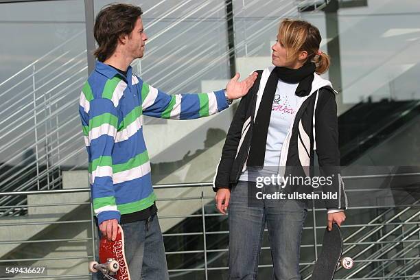 Germany: Young persons in their free time.- Skateboarding; discussion between a young couple.