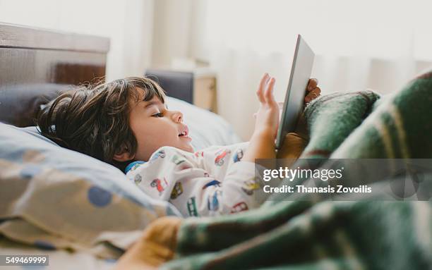 small boy using a digital tablet - child and ipad stockfoto's en -beelden