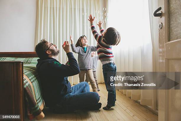 man having fun with his kids - kleine personengruppe stock-fotos und bilder