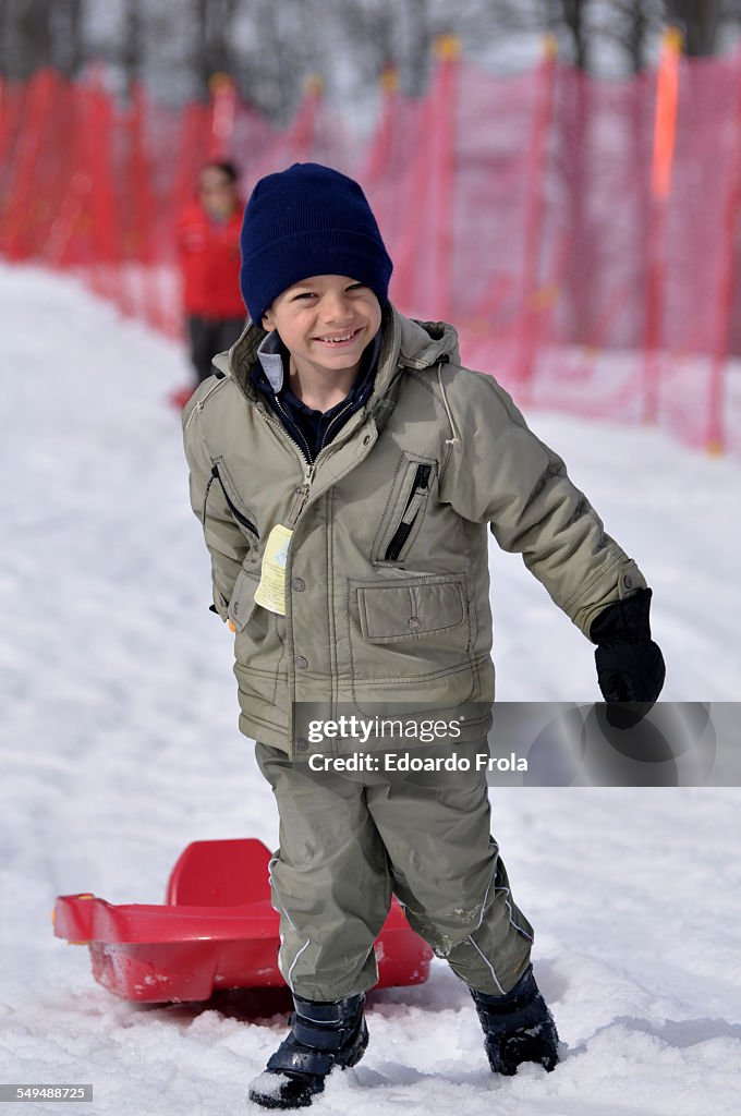 Boy dragging a red bob