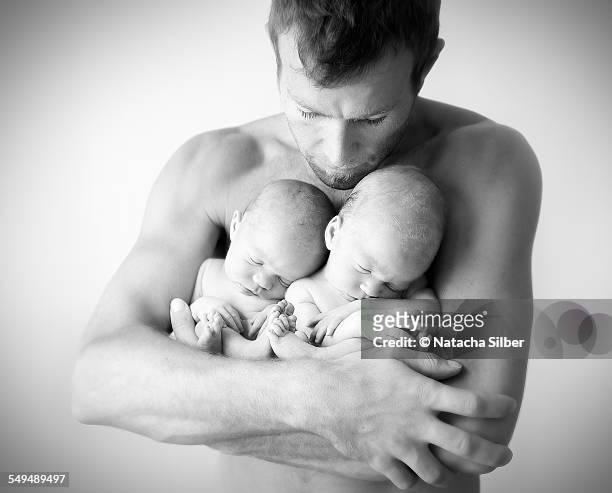 Twins in dads arms