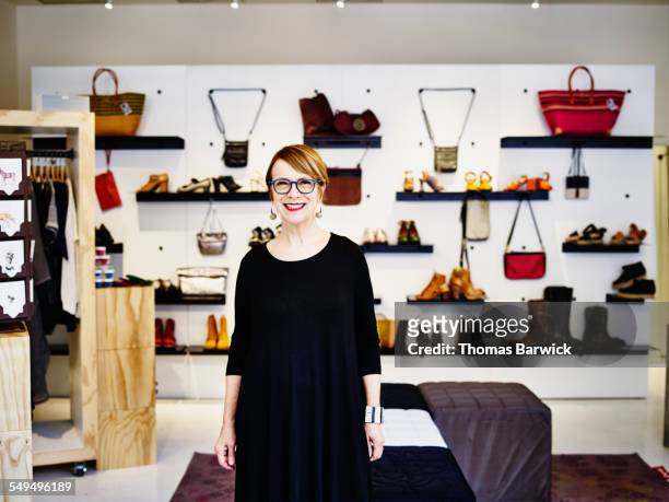 smiling female shop owner standing in boutique - cosmetic sales woman stock-fotos und bilder