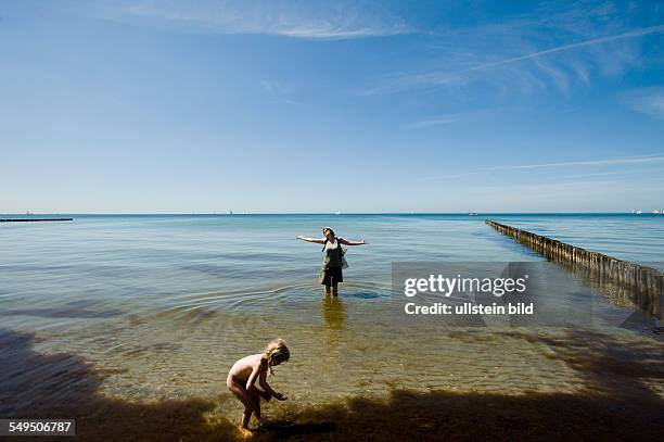 Wasserspiele auf Hiddensee am Gellen. Frau und Kind im flachen Wasser, Deutschland.