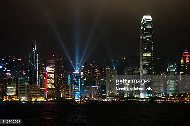 Die Skyline von Hongkong Island mit dem IFC2 Tower bei der naechtlichen Lightshow und ein Schiff im Vordergrund