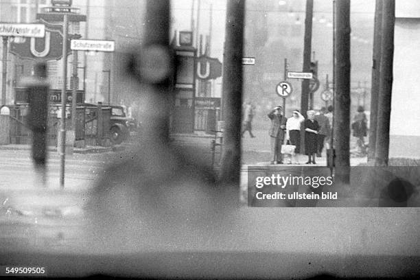 Relatives of a bridal couple at Checkpoint Charlie are waving at them on the East Berlin side at the subway station Stadtmitte