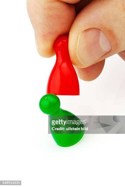 Rote und grüne Spielfiguren. Mobbing, Rauskicken, Wettbewerber
