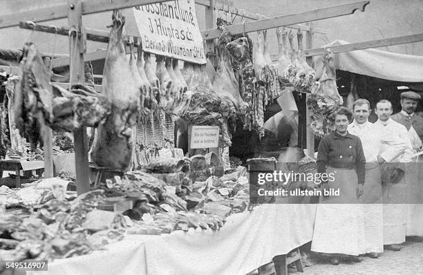 Germany: Butchery Staff next to tables full of meat. Stamp