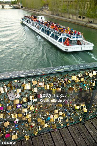 Auf einer Brücke über die Seine in Paris, Frankreich. Verliebte Paare bezeugen ihre ewgie Liebe durch Vorhangschlösser, die sie an das...