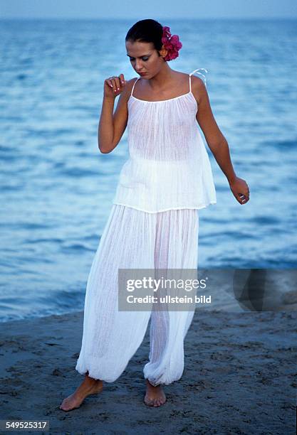 Hippie Mädchen mit roten Bougainvillea-Blumen im Haar, Strand, Ibiza