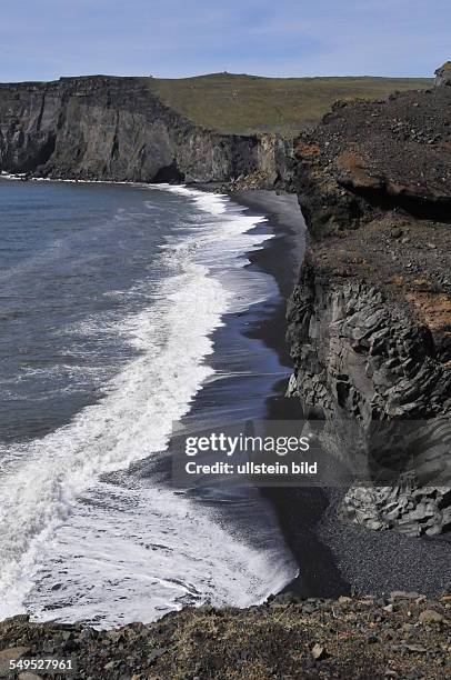 Der schwarze Strandsand und eine Steilküste aus Lavagestein, an der Seevögel brüten, kennzeichnen den südlichsten Punkt Islands am Kap Dyrhóley....