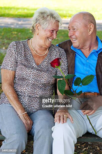 Älteres Senioren Ehepaar ist verliebt. Mann überreicht eine Rose.