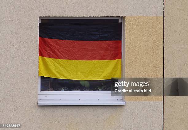 Deutschlandfahne zur Fussball-EM im Fenster eines Plattenbaus