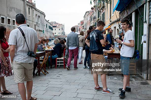 Abends in Venedig sitzen die Menschen unter freiem Himmel und trinken oder Essen in Bars und Restaurants.