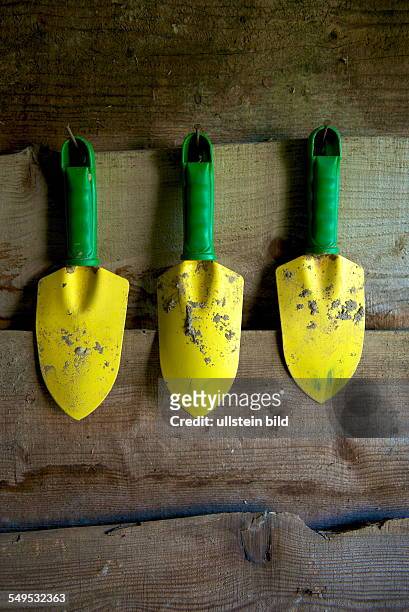 Gartenwerkzeuge. Drei Grün-gelbe Handspaten für das Umpflanzen und Einsetzen von Stauden und Sommerblumen im häuslichen Garten