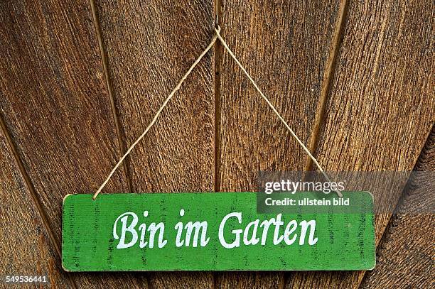 'Bin im Garten'. Ein Schild an der Haustüre sagt dem Besucher, dass der Bewohner im Garten anzutreffen ist