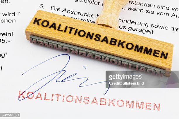 Ein Stempel aus Holz liegt auf einem Dokument. Deutsche Aufschrift: Koalitionsabkommen