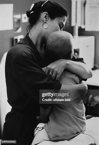 Germany, mother with her son who suffers from cancer in a hospital after chemo-therapy.