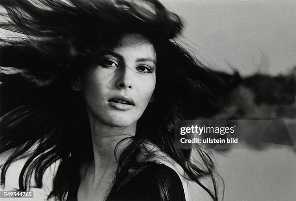 Germany, face of young woman with hair flying in the wind.