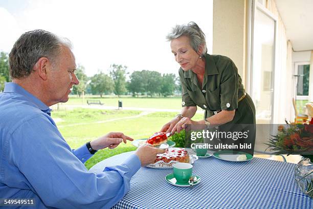 Bonn: Living in old age: Seniors couple eating cake and drinking coffee.